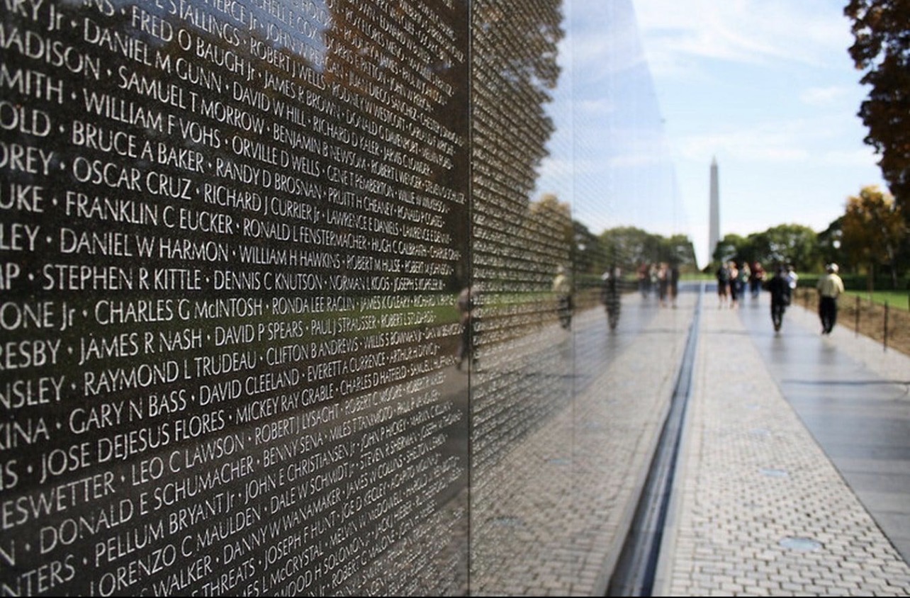 The Vietnam Veterans Memorial wall reflecting the Washington Monument