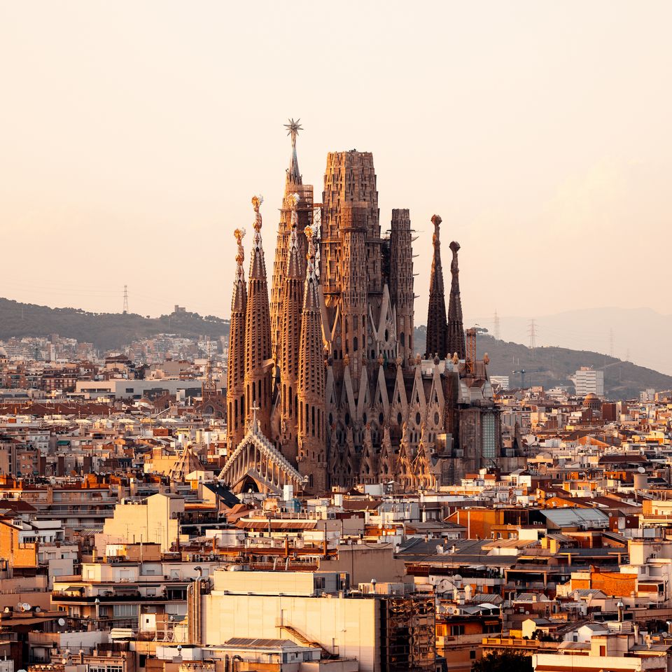 Gaudí's Sagrada Família rising above the rooftops of Barcelona in warm evening light